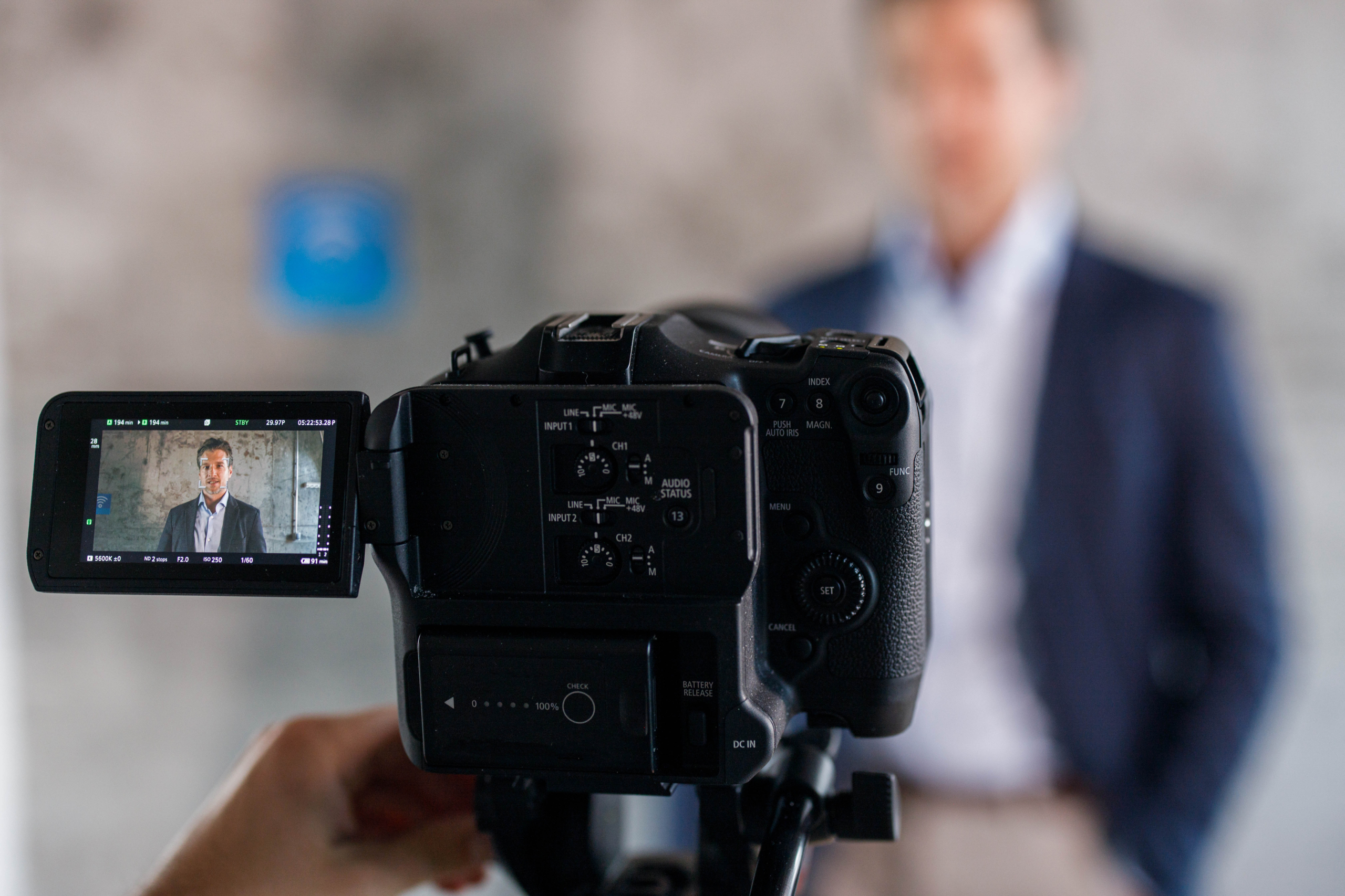 Close up of a camera filming male entrepreneur.